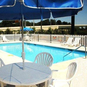 Econo Lodge Pensacola Pool with view of table with umbrella and chairs