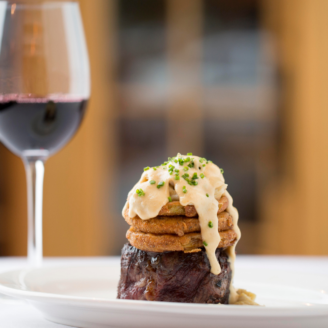Photo of filet mignon topped with lump crab meat from Jackson's Steakhouse served with a glass of red wine